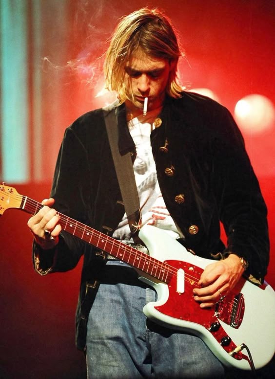 Kurt Cobain smoking a cigarette while onstage during Nirvana\'s MTV: Live and Loud concert in 1993.