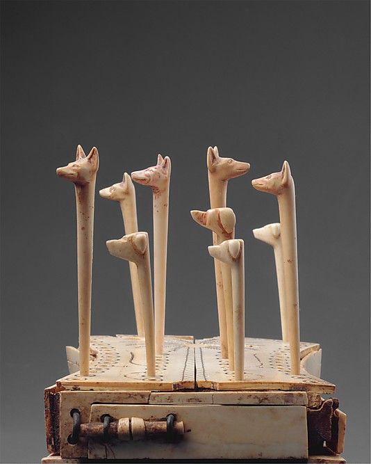 Board Game of Hounds and Jackals, Ivory and Wood The board is raised on 4 bulls' legs. A drawer with a bolt to store the playing pieces. "Egyptians likened the intricate voyage through the underworld to a game." ca. 1814–1805 BCE. Thebes. Tomb of Reniseneb (CC 25), at bottom of shaft. MET.