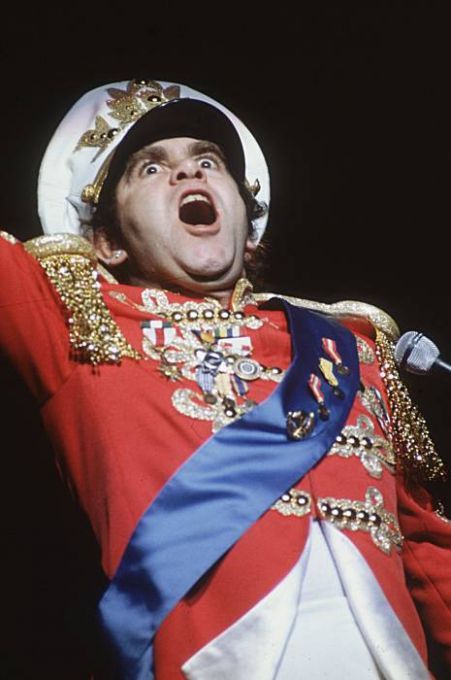 English pop star Elton John performing in a colorful costume at the Hammersmith Odeon.. Photo: Hulton Archive, Getty Images