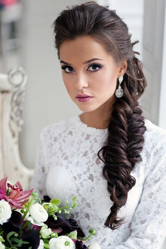 Side swept low ponytail with curls