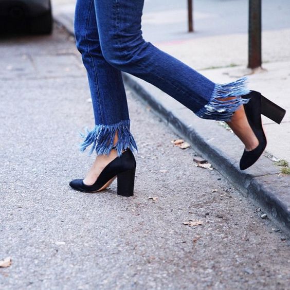 Cropped fringe jeans are paired with black pumps