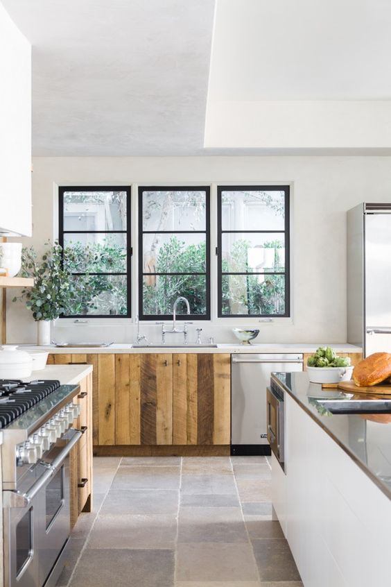 The kitchen sink and fridge in Leigh Herzig's Spanish villa kitchen are conveniently situated alongside a central island, which is topped with stainless steel and has its own integrated sink.