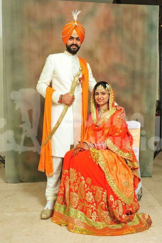 orange bridal lehenga matching with groom shawl and pagdi.