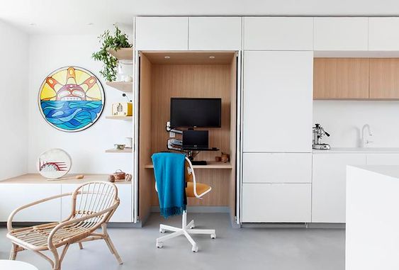 A Small Home Office Is Hidden Within These Minimalist White Kitchen Cabinets