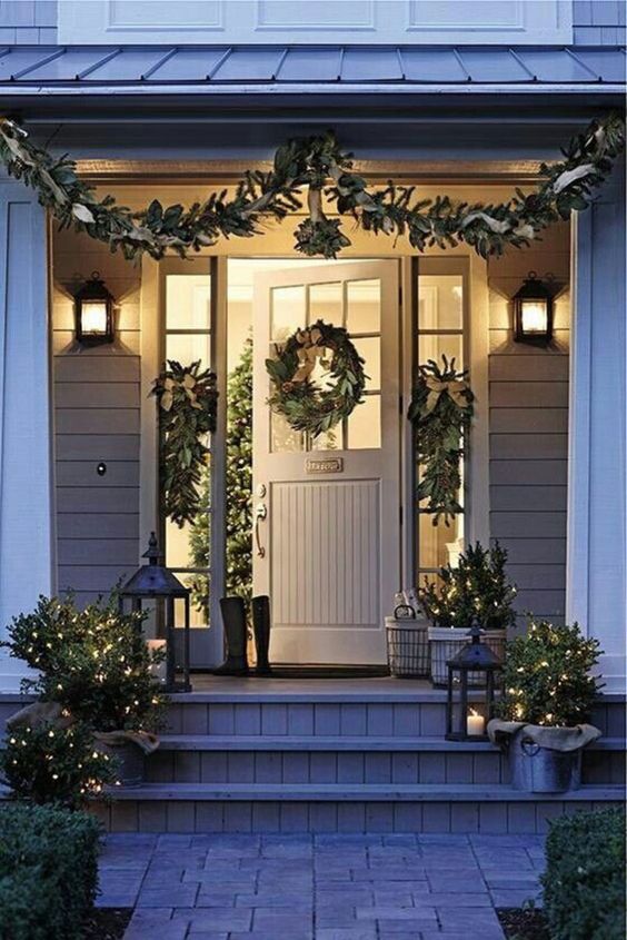 Christmas front door with beautiful wreath, garland, mistletoe, and white lights