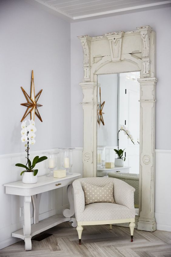 Vintage floor mirror, chubby club chair, and white console table in a modern country foyer in Sarah off the Grid. #SarahRichardson #entryway #foyer