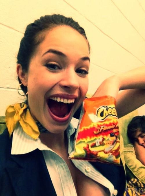 Alexis Knapp on the set of Pitch Perfect with her favorite snack, flaming hot Cheetos Ü