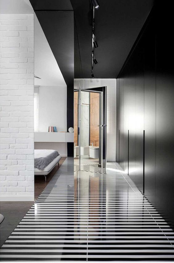 Black And White Striped Flooring And Matte Black Closets Make A Bold Statement In This Bedroom