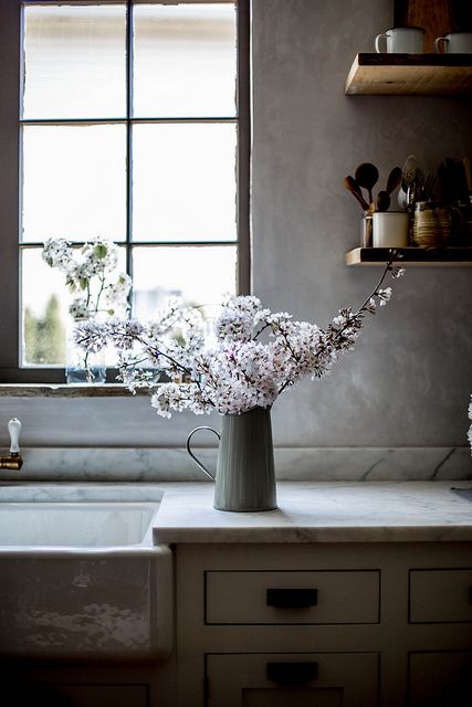 See more of the inspiring kitchen decor and kitchen ideas in Beth Kirby's kitchen. Lovely cherry blossoms in a pitcher on the counter near rustic open shelves. #modernfarmhouse #kitchendecor #kitchenideas #bethkirby #rusticdecor #cherryblossoms