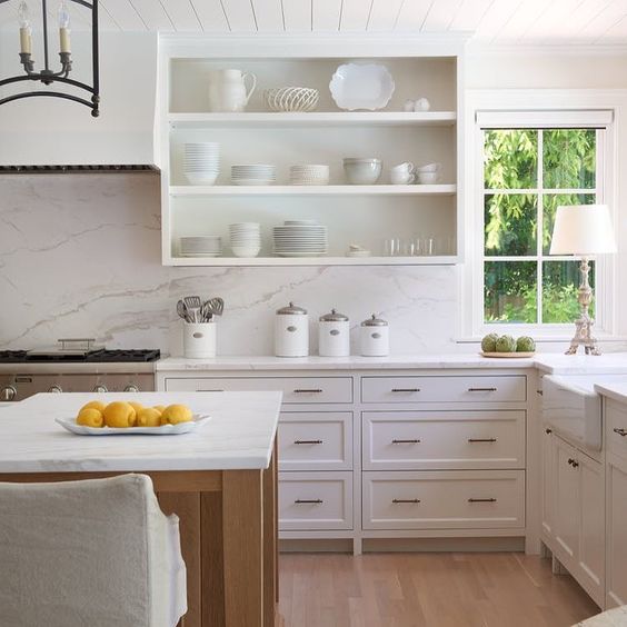 Gorgeous white serene kitchen design with white cabinetry, open shelves, wood floors, and beadboard ceiling.! #kitchendesign #kitchendecor #whitekitchen #whitedecor #shelves #beadboard #serene