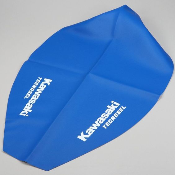 Housse de selle Tecnosel Team 1996 Kawasaki KX 125 et 250 Revêtement de protection de siège conducteur neuf adaptable pour moto cross 125cc et 250cc Kawasaki KX de 1994 à 1998. Pour le remplacement de la housse vous pouvez faire appel aux services d\'un cordonnier ou bien réaliser vous même l\'opération. Pour cela vous devez extraire les agrafes de fixation de l\'ancienne housse avec un tournevis plat puis remonter la nouvelle à l\'aide d\'une agrafeuse électrique ou pneumatique. Choisissez des agraf