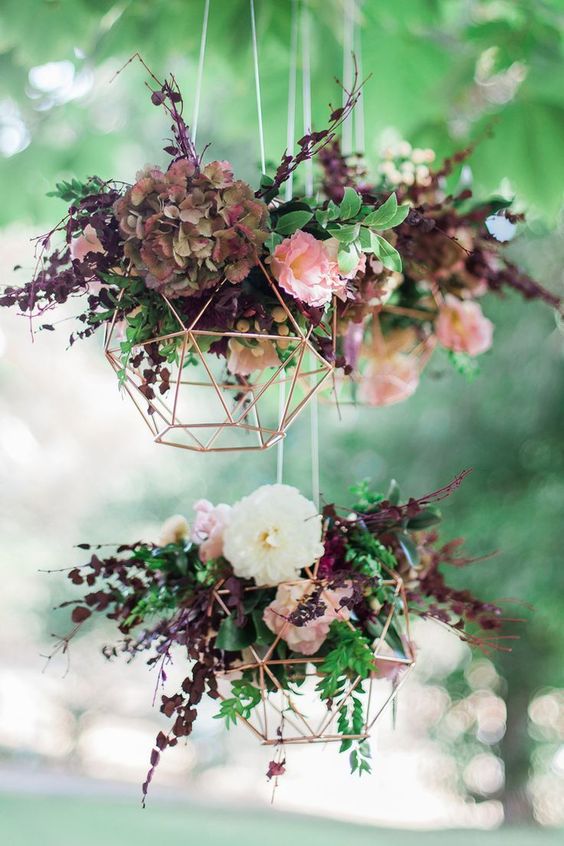 You Will Love This New Trend of Geometric Terrarium Decor! | Geometric copper wedding reception hanging feature with burgundy flowers | terrarium decor ideas | geometric wedding decor ideas | terrarium decor | terrarium decor for weddings | terrarium jars | gecko terrarium | indoor terrarium | hanging terrarium | glass terrarium | table top decor | evening wedding decor | terrarium pots | Function Mania