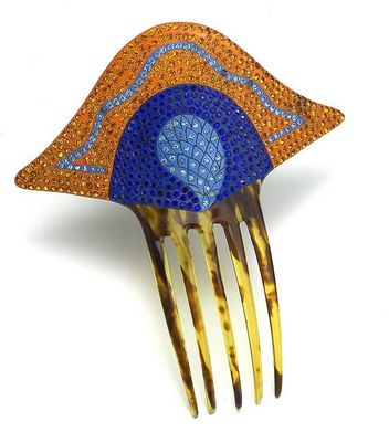 This English Art deco comb is painted orange with two colors of blue. Rhinestones match the paint. The decoration was painted on faux tortoiseshell. c. 1920