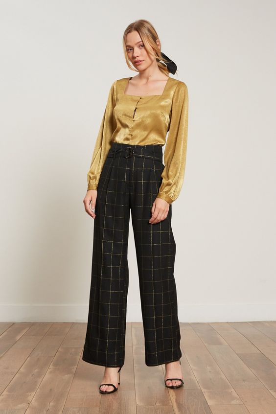 FINAL SALE Black with gold plaid print belted trouser. Features Polyester blend Zip up Wide Leg Belted at waist Model is wearing size x-small This style has an impeccable fit! Fabric Garment Care Each item we make is produced and handled with care. We encourage you to consider the environment when cleaning our items. We recommend you hand wash this product and hang to dry.
