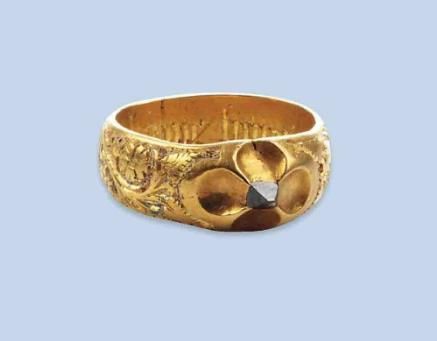 A RARE LATE MEDIEVAL DIAMOND RING The ring of band design, the upper part of the ring engraved with flowers and showing traces of blue enamel, centering an octahedral diamond within a quatrefoil mounting, inner engraving “En Bonne Heure” 15th Century