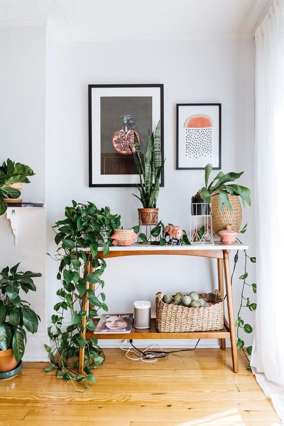 Swedish inspired vignette with a midcentury modern table styled with plants, and art above