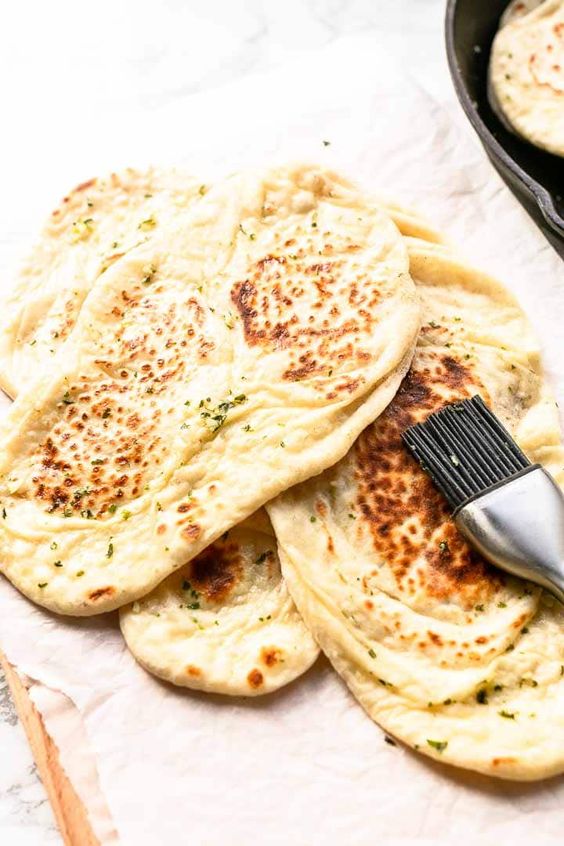 Want to make soft, fluffy naan bread? Try this easy naan bread with garlic recipe. Just as good as any restaurant naan. Serve with your favorite curry. Visit thetortillachannel.com for the full recipe #thetortillachannel #garlicnaan #naanwithgarlic #naan #naanbread #garlicnaanrecipe