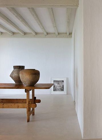 Axel Vervoordt Interior Design Inspiration {Minimal Decorating} Minimal, simple interior design by #AXELVERVOORDT for Calvin Klein's home in Miami with #rusticdecor dinning table, beamed ceiling, concrete floor, and ancient pottery
