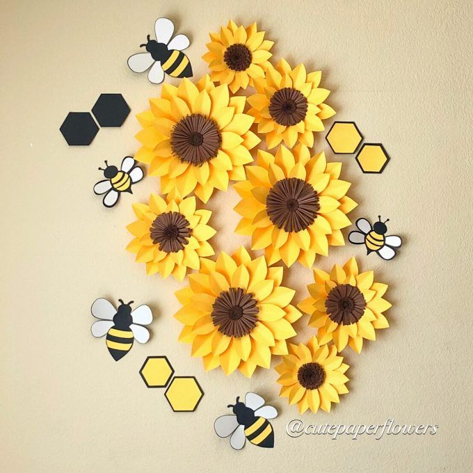 paper sunflowers and bees are arranged in the shape of honeycombs on a wall