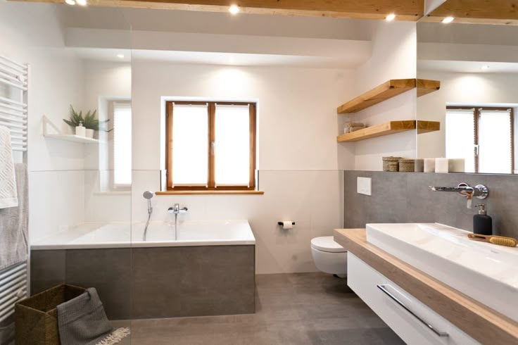 Badsanierung: Schickes Wohlfühlbad mit viel Holz und modernen Fliesen in Betonoptik von Banovo GmbH