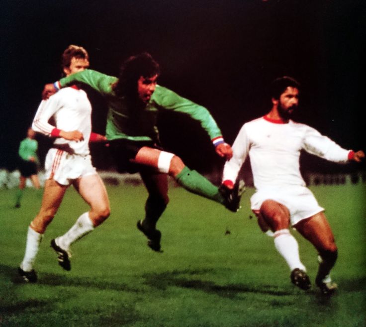 three men are playing soccer on the field