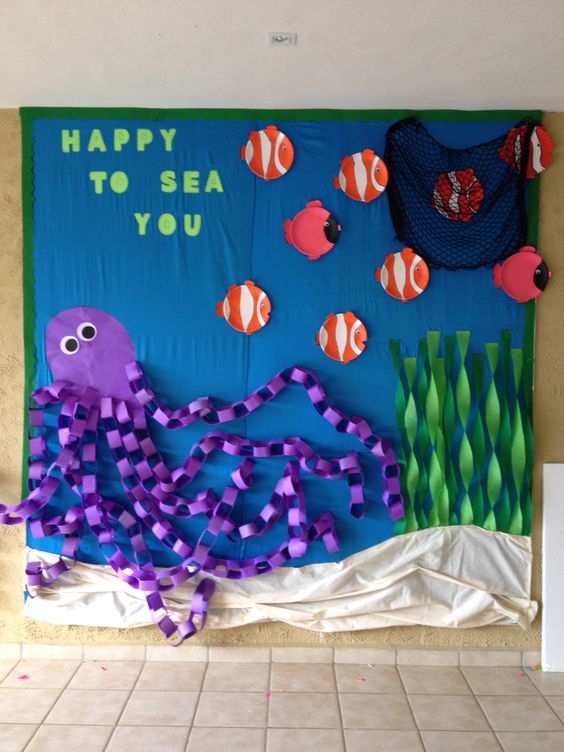 a bulletin board with an octopus and other sea creatures on it's side, in front of a tiled floor