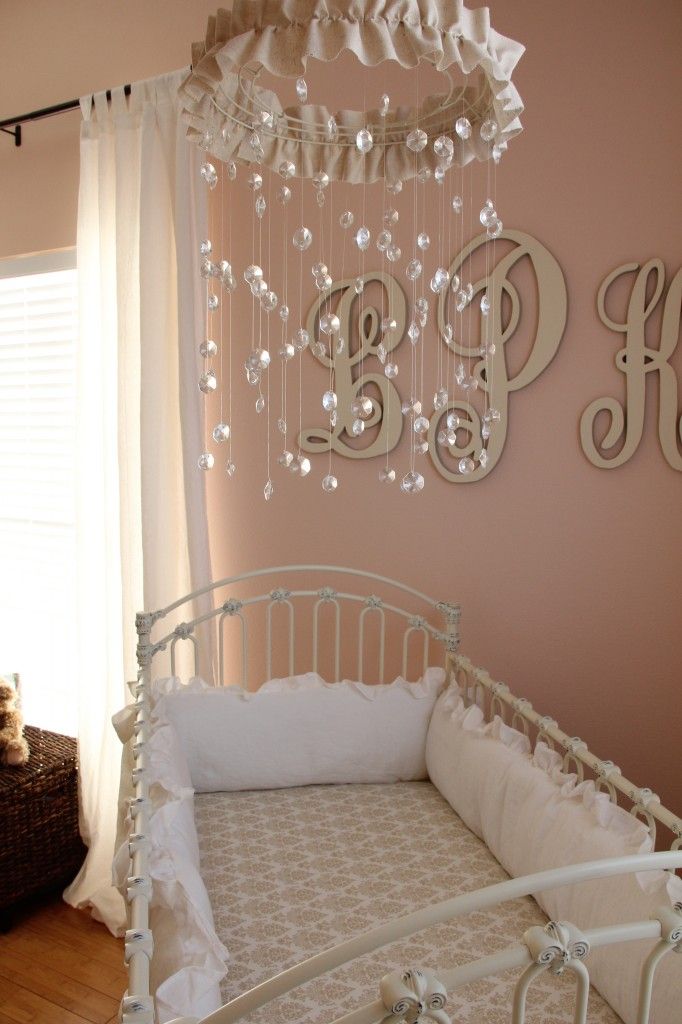 a baby crib with a chandelier hanging from the ceiling