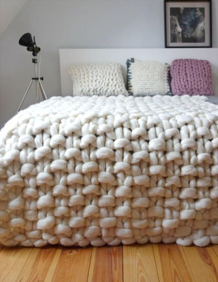 black and white photograph of a bedroom with a large blanket on top of the bed