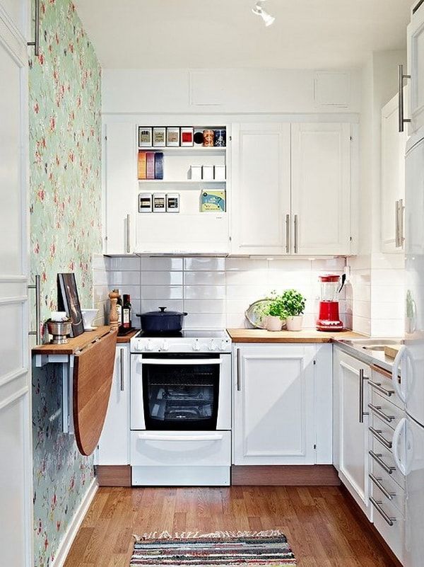 a small kitchen with white cabinets and wood flooring on the walls, along with an area rug that matches the hardwood floor