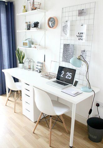 Ein minimales Home-Office im Scandi-Stil mit einem weißen Schreibtisch und zwei...