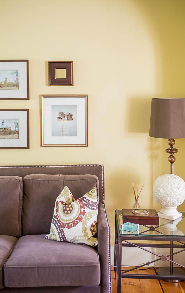 A Cheerful Living Room Featuring Yellow Walls Purple Couch Patterned Cushions And Wall Colors Yellow Walls Living Room, What Color Sofa With Yellow Walls