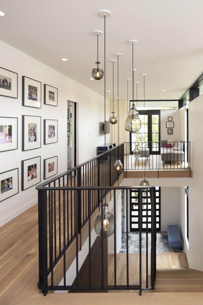 an open floor plan with pictures on the wall and stairs leading up to the second floor