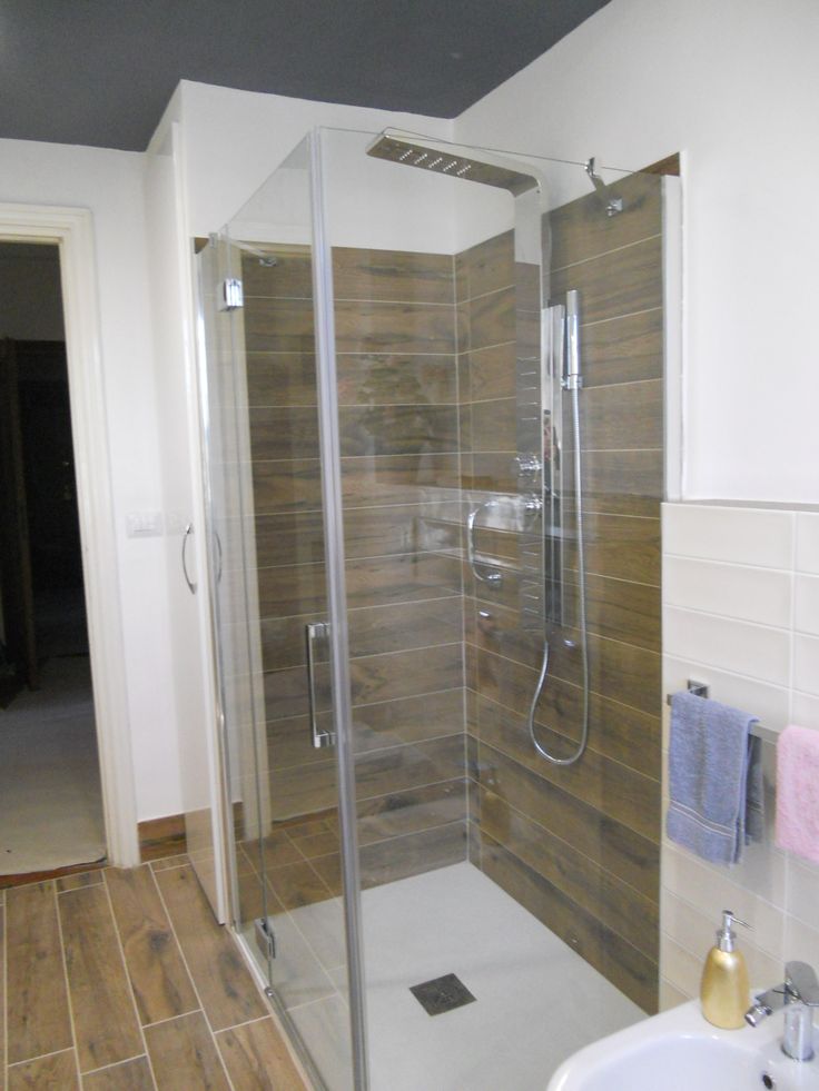 a walk in shower sitting next to a white sink