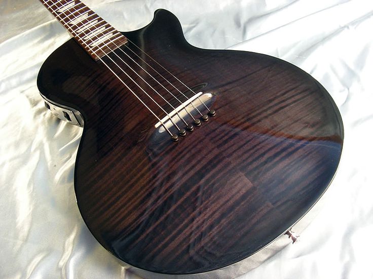 a close up of a guitar on a white sheet