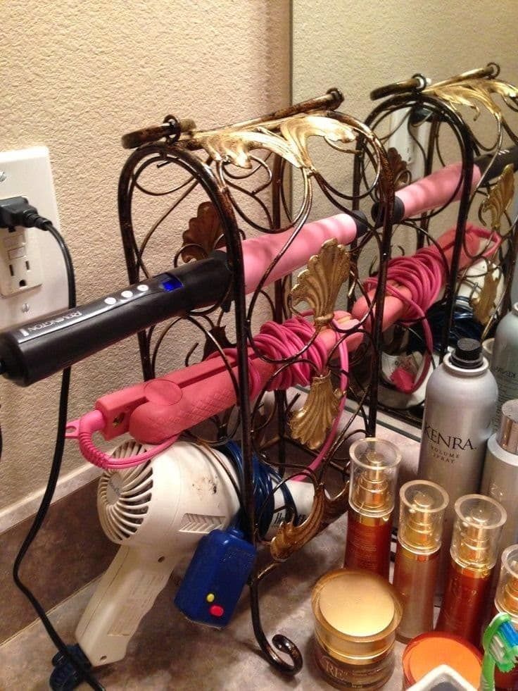 an image of a rack full of wine glasses and other items on the counter in front of a mirror