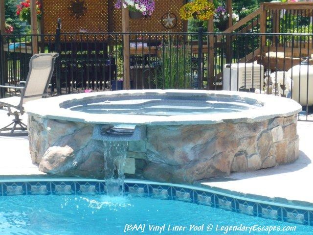 Raised spillover spa with custom stone work around the spa ...