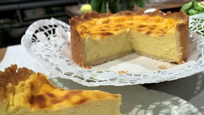 Angeschnittener Käsekuchen auf einer Platte, ein Stück