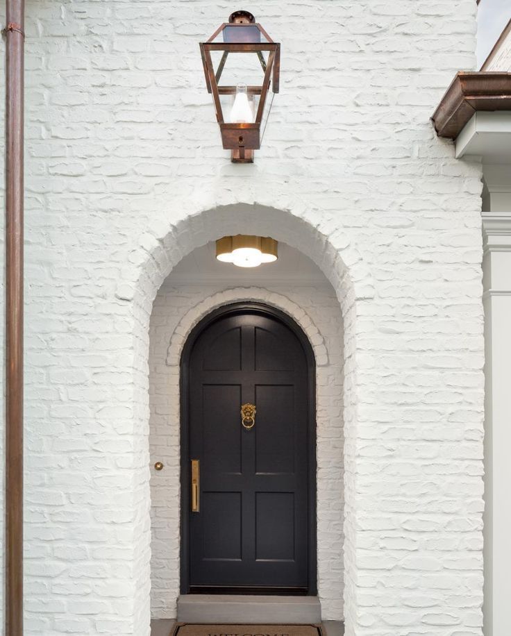 White Brick Exterior Bronze Lantern Sconce Rounded Archway White Brick Exterior Bronze Lantern Sconce Rounded Archway Round Arched Front Door With Knocker And Gold Design