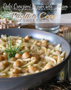 pasta with chickpeas and cream sauce in a bowl next to silver utensils