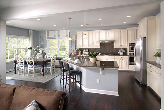 a kitchen and living room with hardwood floors in it's center area, along with an open floor plan