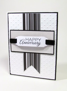 a white and black card with a happy anniversary tag on it's front corner