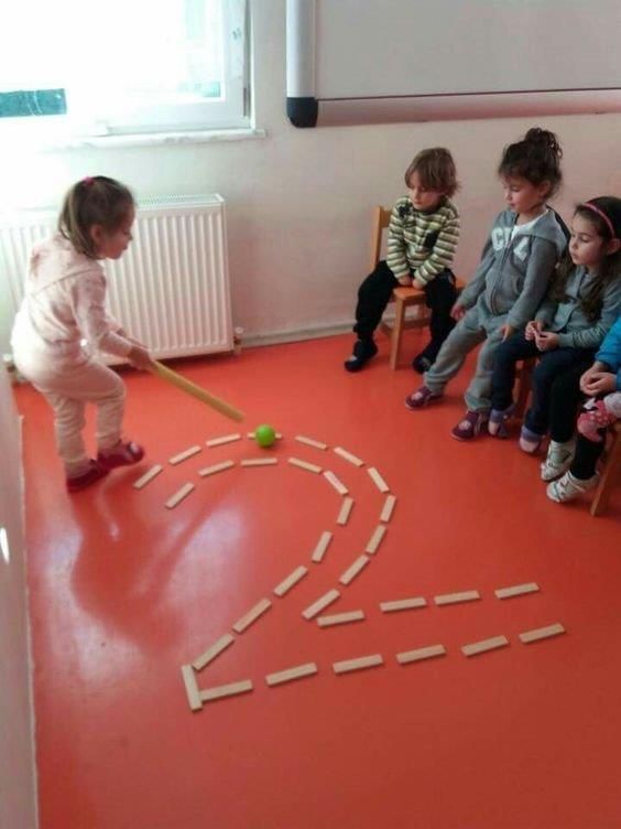 children are sitting on chairs and playing with wooden sticks