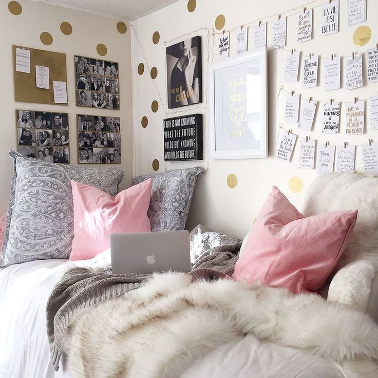 a laptop computer sitting on top of a bed in a room filled with pictures and pillows