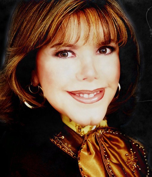 a close up of a person wearing a black jacket and gold blouse with a