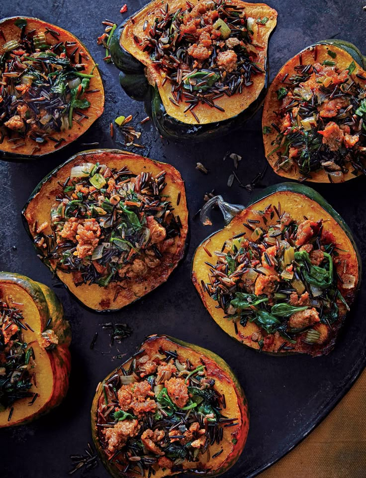 several stuffed sweet potatoes with various toppings on a black platter, ready to be eaten