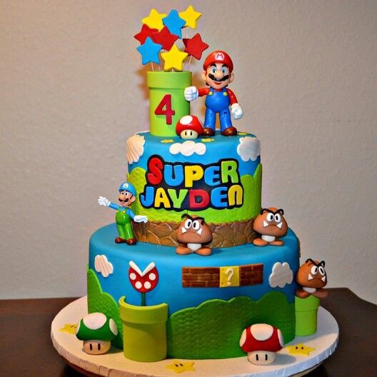 a blue and green birthday cake with mario on top