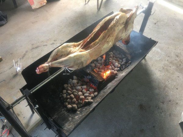 a large piece of meat cooking on an outdoor grill