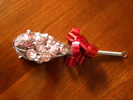 kitchen whisk filled with hershey kisses with a little christmas gifts for neighbor
