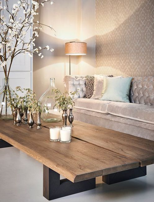 a living room with a couch, table and flowers in vases on the coffee table