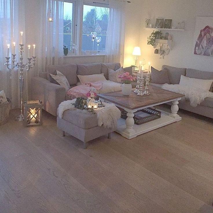 a living room filled with lots of furniture and candles on top of it's coffee table